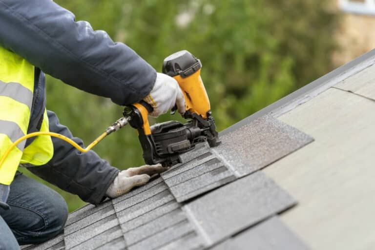 Roofer working on a shingle roof replacement