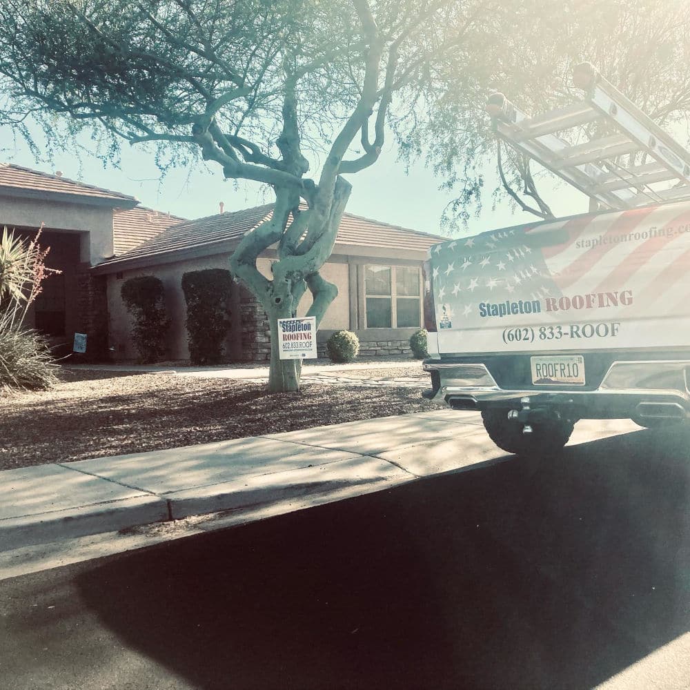 Stapleton Roofing truck parked in front of a customer house